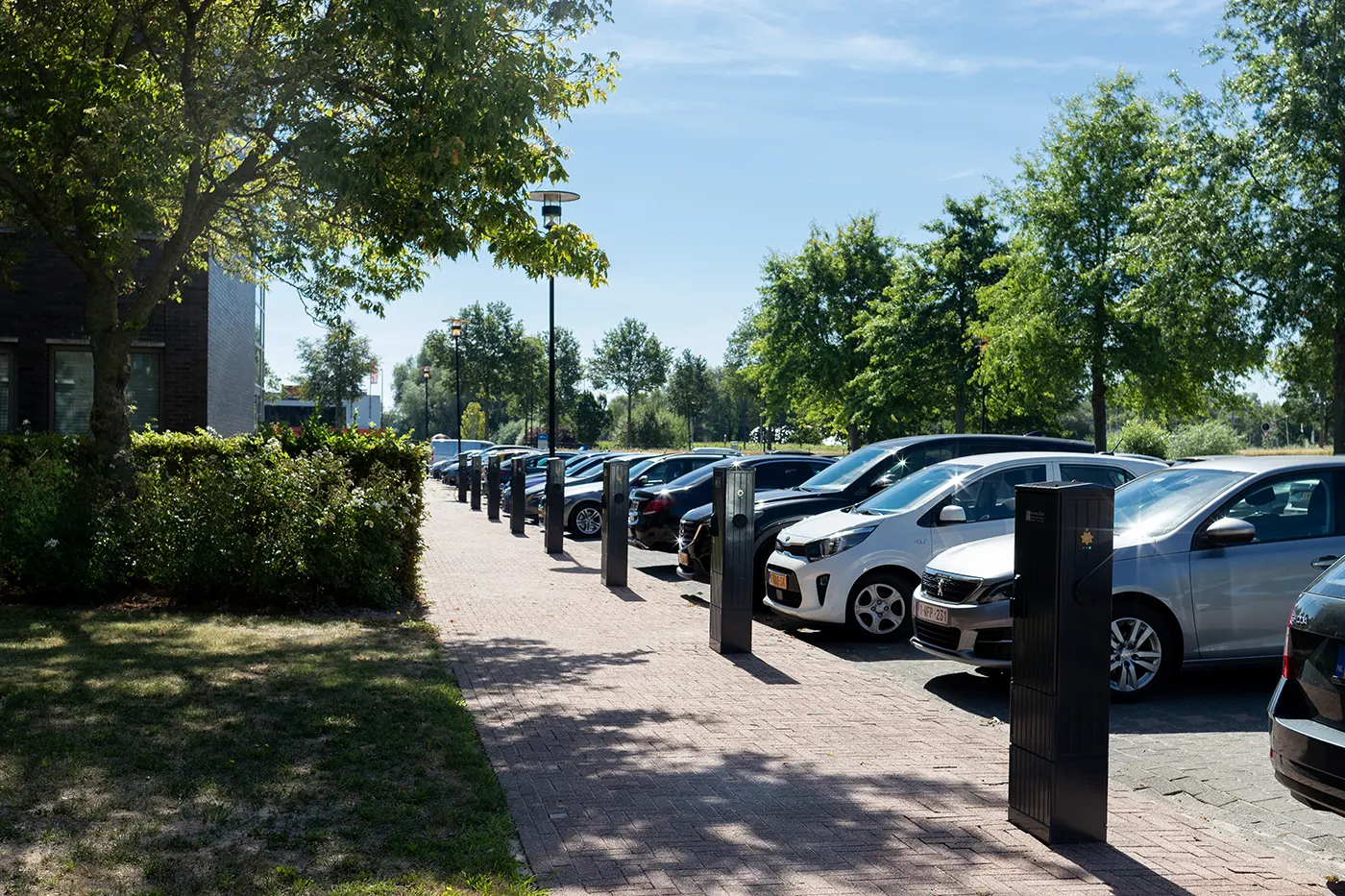 Elektrische auto's aan laadpalen in groene parkeeromgeving The Green Box
