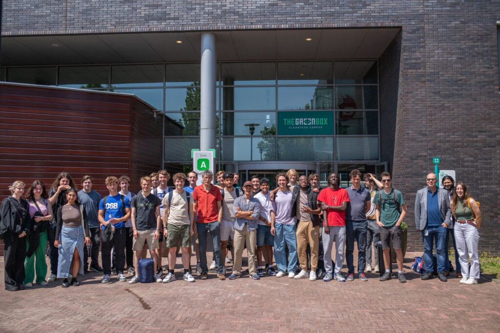 Groep studenten en docenten poseren voor The Greenbox Cleantech Campus gebouw tijdens educatieve excursie