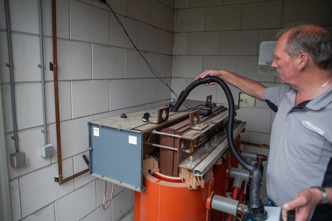 Technicus bedient industriële machine met stofzuiger voor technisch onderhoud