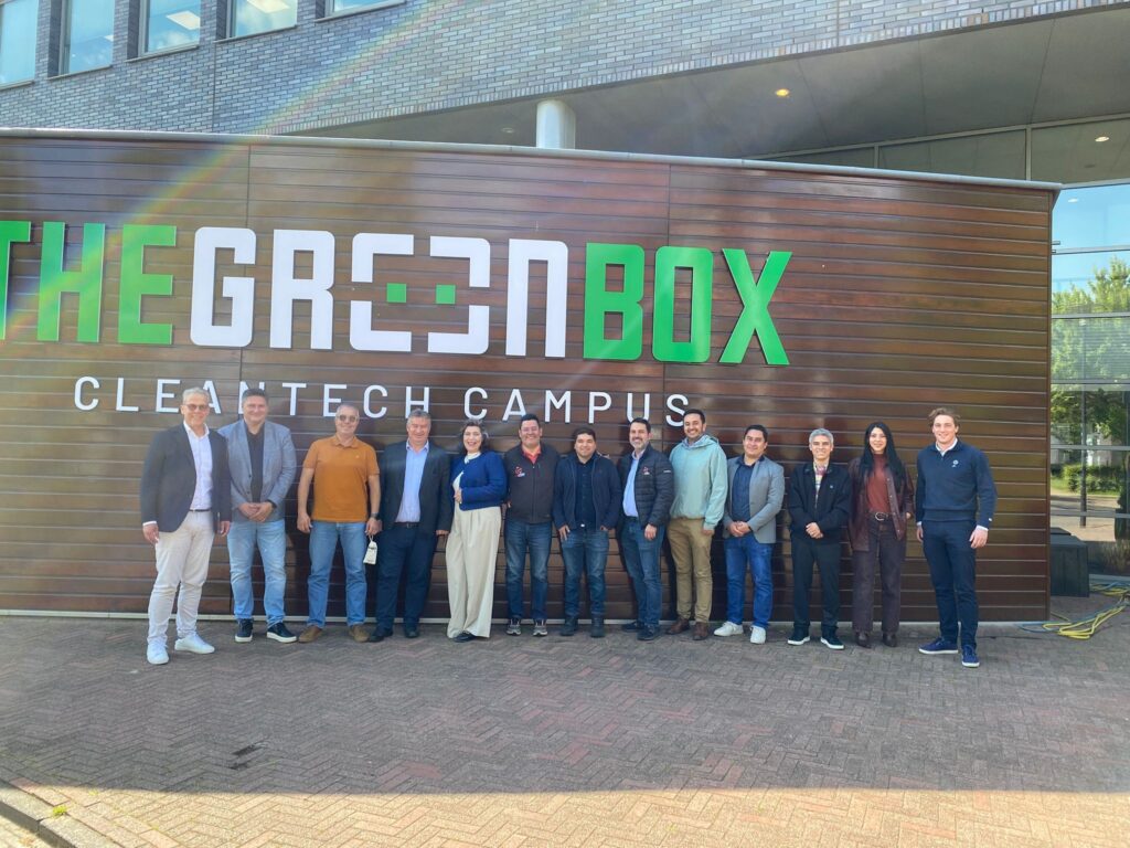 Groepsfoto van professionals voor het GreenBox CleanTech Campus gebouw met houten gevel en moderne architectuur.