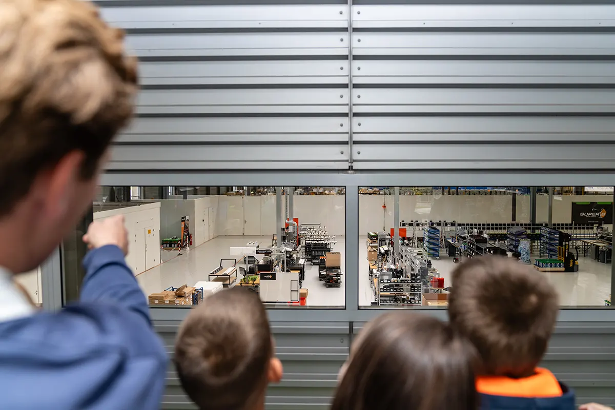 Gerard Nijsse wijst productielocatie laadpalen basisschool leerlingen